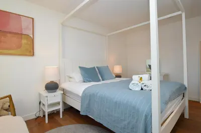 a bedroom with a bed with blue pillows at Old Fire Station in Tighnabruaich