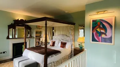 a bedroom with a canopy bed and a fireplace at Townhead in Peebles