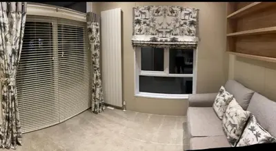 a living room with a couch and a window at Loubet Extra Large Lodge in Auchterarder