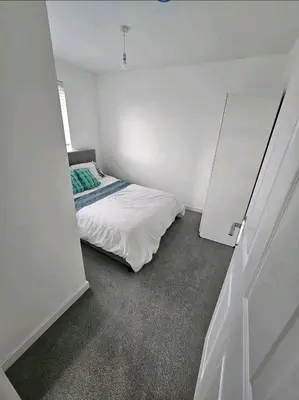 a bedroom with a bed in a white room at Darnley southside room in a private home 61 Leggastston Road in Pollokshaws