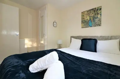 a bedroom with a bed with a blue blanket on it at Signature - Shield House in Scotstoun