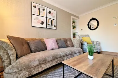 a living room with a couch and a table at Signature - Shield House in Scotstoun