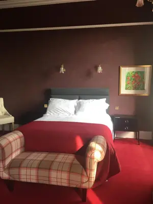 a bedroom with a bed with a red carpet at Moorlands in Helensburgh