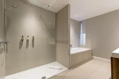 a bathroom with a shower and a tub and a sink at Destiny Scotland - Hill Street Apartments in Edinburgh