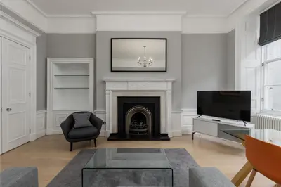 a living room with a fireplace and a television at Destiny Scotland - Hill Street Apartments in Edinburgh