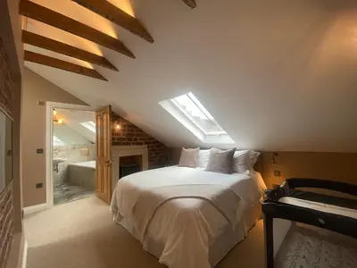 a bedroom with a white bed with a skylight at Ashton View in Glasgow