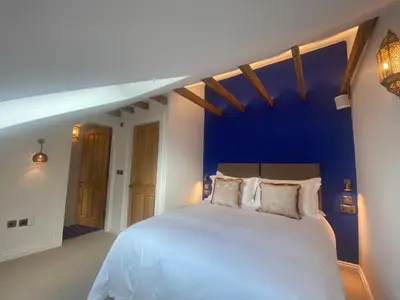 a bedroom with a large white bed with a blue wall at Ashton View in Glasgow