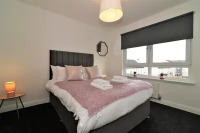 a bedroom with a bed with two towels on it at Signature - Belvidere House in Glasgow