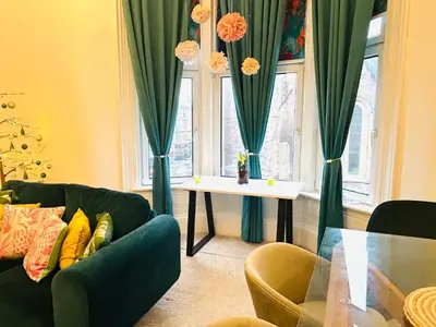 a living room with two couches and a table and a window at Glasgow Center/West End Apartment in Glasgow