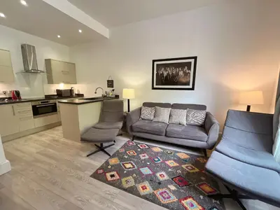 a living room with a couch and a kitchen at King’s stable 2 rooms in Edinburgh
