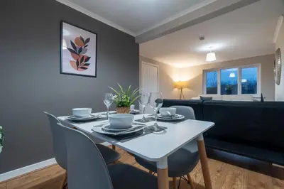 a dining room with a white table and chairs at 2 BDR Apt By Caledonia Luxe Stays Short Lets & Serviced Accommodation Bishopton in Bishopton