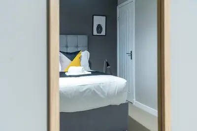 a mirror reflection of a bed in a bedroom at 2 BDR Apt By Caledonia Luxe Stays Short Lets & Serviced Accommodation Bishopton in Bishopton