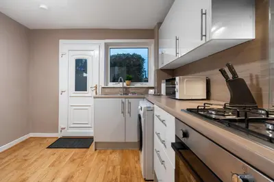a kitchen with white cabinets and a counter top at 2 BDR Apt By Caledonia Luxe Stays Short Lets & Serviced Accommodation Bishopton in Bishopton