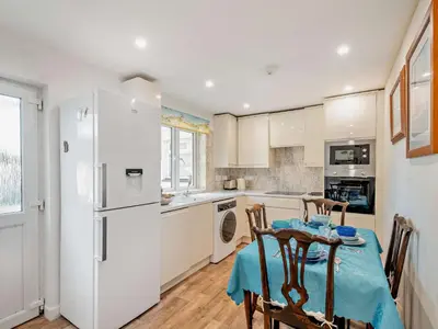 a kitchen with a table and a white refrigerator at 1 Bed in Inveraray 91310 in Crarae