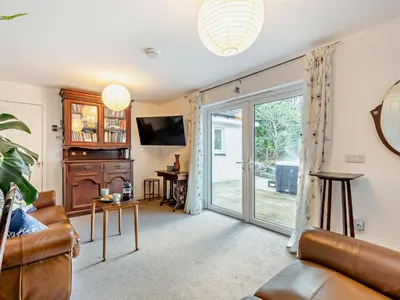 a living room with a couch and a sliding glass door at 1 Bed in Inveraray 91310 in Crarae