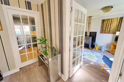 a living room with a glass cabinet with a plant in it at Charming 2BD House - Parking & Garden in Oban in Oban