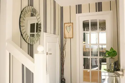 a hallway with striped walls and a mirror on the wall at Charming 2BD House - Parking & Garden in Oban in Oban