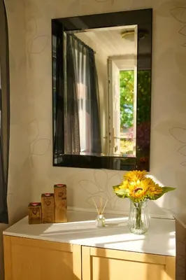 a bathroom sink with a mirror and a vase of flowers at Charming 2BD House - Parking & Garden in Oban in Oban