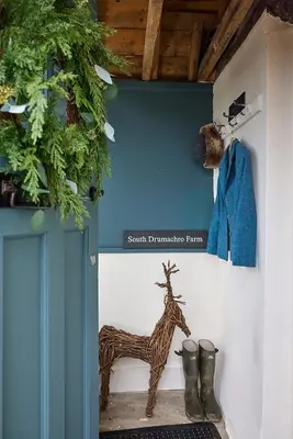 a painting of a giraffe and boots on a wall at ISLE OF GIGHA FARM HOUSE in Isle of Gigha