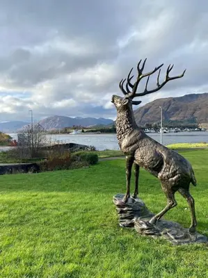 a statue of a deer statue in a field at Scottish Highland house Fort William in Corran