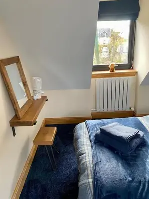 a bedroom with a bed and a mirror and a window at Scottish Highland house Fort William in Corran