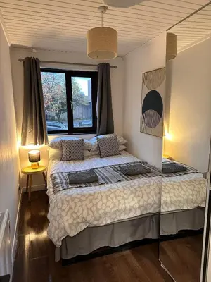 a bedroom with a large bed with a window at BrightCentral Apartment With Parking in Glasgow