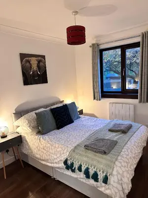 a bedroom with a bed and a picture of an elephant at BrightCentral Apartment With Parking in Glasgow