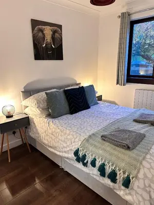 a bedroom with a bed with an elephant picture on the wall at BrightCentral Apartment With Parking in Glasgow