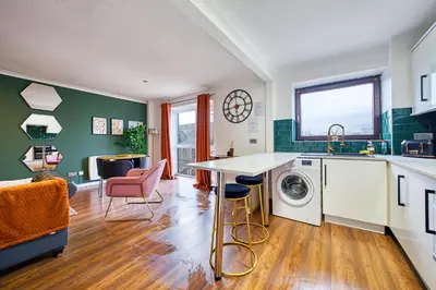 a kitchen with a washing machine and a table at New Slick Finnieston Pad w/ Free Parking in Glasgow