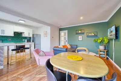 a living room with a table and a kitchen at New Slick Finnieston Pad w/ Free Parking in Glasgow