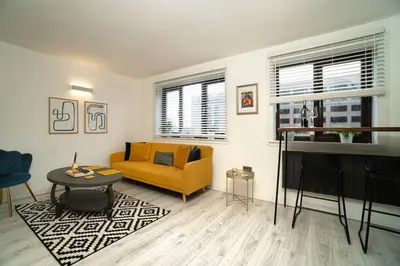 a living room with a yellow couch and a table at Stylish City Pad with Free Private Parking in Glasgow