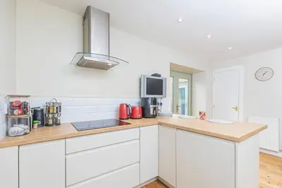 a kitchen with white cabinets and a counter top at The Gate House - 3 Bed & Parking in Edinburgh