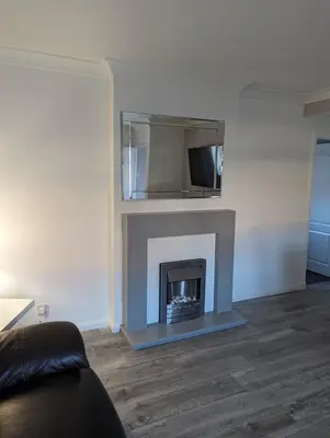 a living room with a fireplace with a tv at Lovely 2 Bedroom Terrace House in Coatbridge