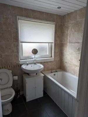 a bathroom with a sink and a toilet and a bath tub at Lovely 2 Bedroom Terrace House in Coatbridge