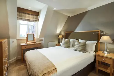 a bedroom with a large white bed and a window at Crieff Hydro in Crieff