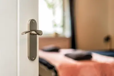 a door with a door knob in a room with beds at Sleek and Stylish 3 Bed in Greenock - Sleeps 8 in Greenock