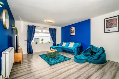 a living room with blue walls and a blue couch at Sleek and Stylish 3 Bed in Greenock - Sleeps 8 in Greenock