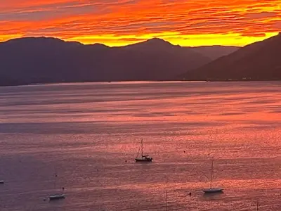 a group of boats in the water at sunset at Waverley Apartments, The Wheelhouse in Gourock