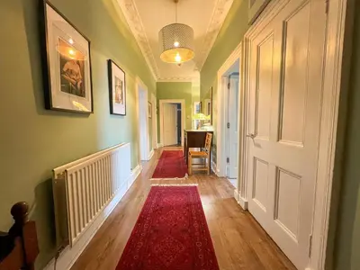 a hallway with a red rug and a white door at Garnethill Charm 3 Bed Flat Central Glasgow in Glasgow