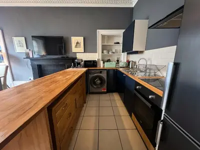 a kitchen with a washer and dryer in it at Garnethill Charm 3 Bed Flat Central Glasgow in Glasgow
