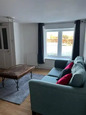 a living room with a couch and a coffee table at Fairness Cottage, Near Comrie in Comrie