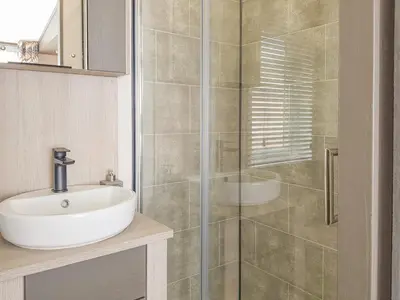 a bathroom with a sink and a glass shower at Ben Vorlich Lodge in Saint Fillans