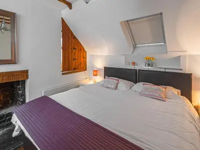 a bedroom with a large white bed with two pillows at Craigdarroch Cottage in Saint Fillans
