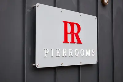 a sign on a wall with the letter r premier at The Pier Rooms in Oban