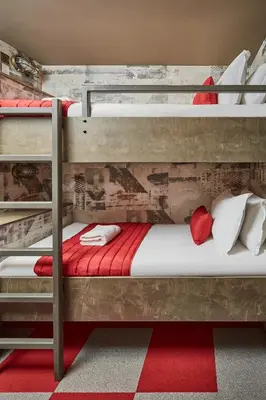 a bedroom with two bunk beds with red and white pillows at The Pier Rooms in Oban