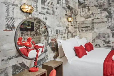 a bedroom with a mirror and a bed with red pillows at The Pier Rooms in Oban