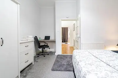 a bedroom with a bed and a desk and a chair at Stunning Ground Floor flat in Southside. in Glasgow