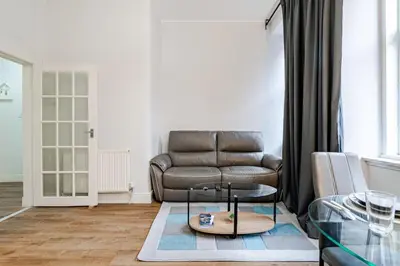 a living room with a couch and a glass table at Stunning Ground Floor flat in Southside. in Glasgow