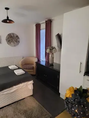 a bedroom with a bed and a chair at Luxe rooms in Edinburgh