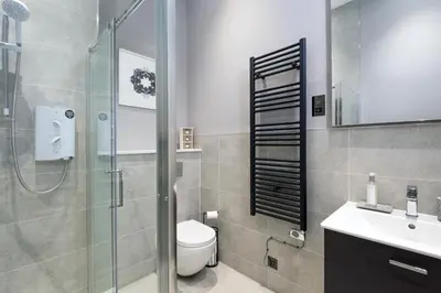 a bathroom with a shower and a toilet and a sink at Modern George Street Studio sleeping 2 in Edinburgh